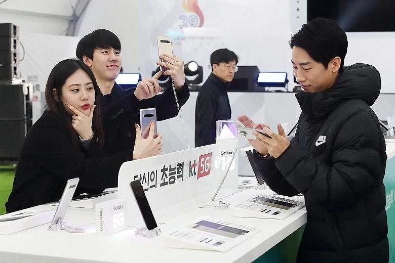 Visitors to the KT 5G Experience Zone in Gwanghwamun Plaza in Seoul trying out Samsung's first 5G phone, the Galaxy S10 5G, last month. Competition to be first in 5G is stiff, as other countries, including the United States and China, are also eager 