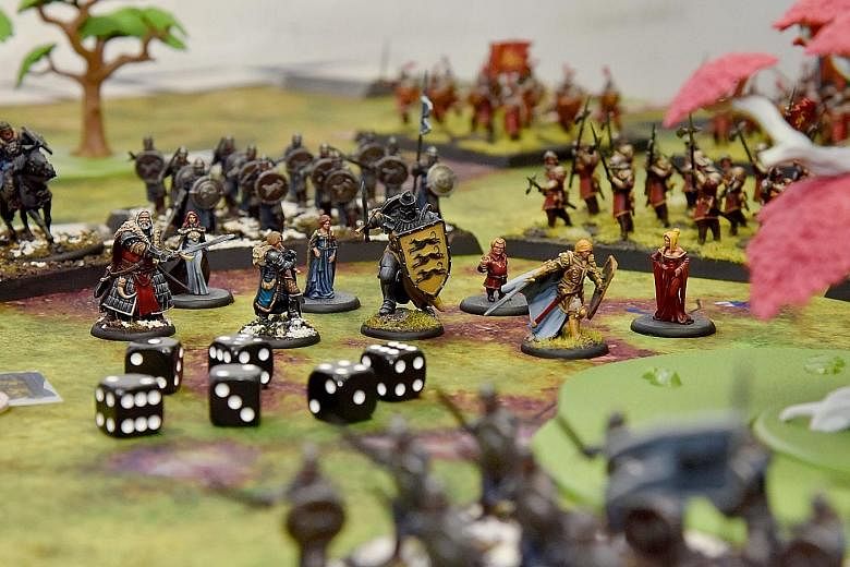 Illustrator Russell Ng (far left), 29, a Game Of Thrones fan, playing the A Song Of Ice And Fire tabletop miniatures game at Gamersaurus Rex. The game, which launched six months ago after a successful Kickstarter bid, has tiny figures (above) that th