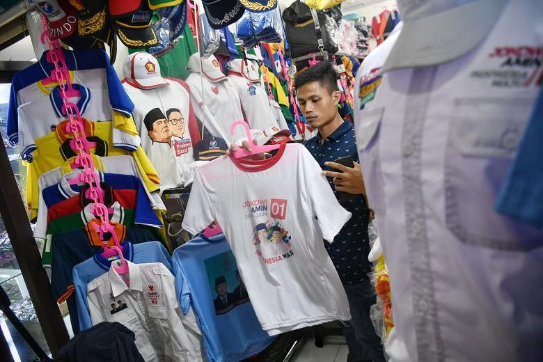 Mr Acep Abdul Aziz (above) said his shop at Jakarta's historic market, Pasar Senen, is seeing a 50 per cent increase in orders for election merchandise such as T-shirts, caps, jackets, banners and name cards. Buttons featuring images of presidential 