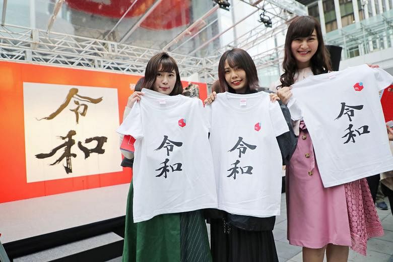 Women showing off T-shirts printed with the new era name "Reiwa". The T-shirts were distributed for free at an event in Tokyo on Monday.
