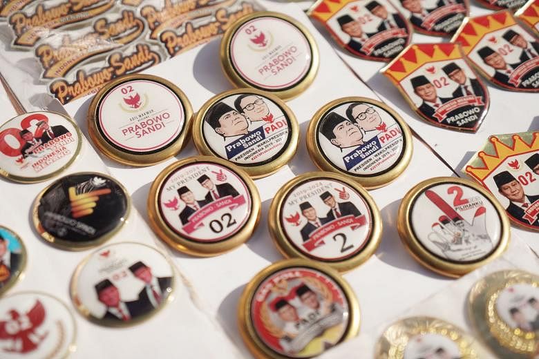 Mr Acep Abdul Aziz (above) said his shop at Jakarta's historic market, Pasar Senen, is seeing a 50 per cent increase in orders for election merchandise such as T-shirts, caps, jackets, banners and name cards. Buttons featuring images of presidential 