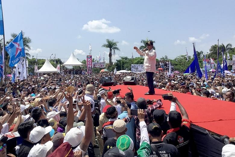 Mr Prabowo speaking in Ciamis yesterday, where he promised, if elected, to cut electricity costs within his first 100 days in office. A crowd bidding farewell to Mr Prabowo Subianto in Ciamis regency after his campaign stop there yesterday. The modes