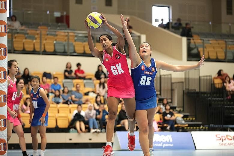 Mission Mannas' Rochelle Teiri challenging Blaze Dolphins' Premila Hirubalan for the ball at Our Tampines Hub yesterday. Defending champions Dolphins beat Mannas 52-39 for a spot in next Saturday's Netball Super League grand final.