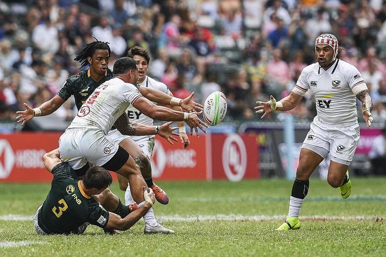 Martin Iosefo passing the ball to a teammate while being tackled by Impi Visser of South Africa yesterday. The US defeated the Blitzboks 21-12 in their Hong Kong Sevens quarter-final but fell 28-19 to eventual champions Fiji in the semi-finals. They 