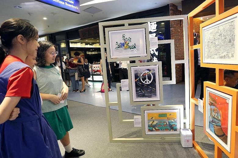 Pupils looking at works on display at the opening of the Top 50 Finalists Exhibition of the School of the Arts (Sota) Primary 6 Art Competition 2019 yesterday, which Education Minister Ong Ye Kung also visited. The annual visual arts competition, now