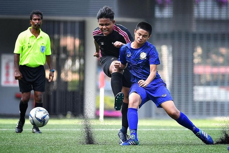 Spectra Secondary School's Muhd Zahin Hidayatullah taking a shot under the challenge of St Gabriel's defender Gideon Tai during the Schools National B Division boys' League Three football final at Our Tampines Hub yesterday. St Gabriel's won 2-0.