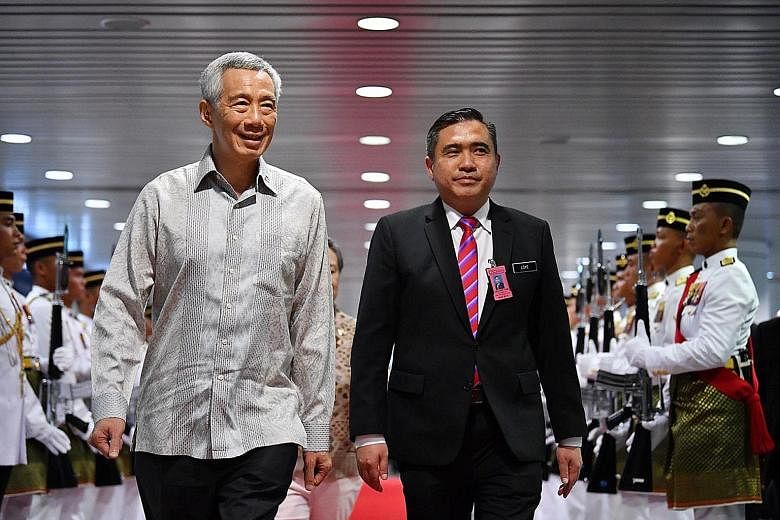 Prime Minister Lee Hsien Loong inspecting a guard of honour on his arrival at Kuala Lumpur International Airport yesterday, accompanied by Malaysian Transport Minister Anthony Loke. This is the first Leaders' Retreat with Malaysia's Pakatan Harapan g