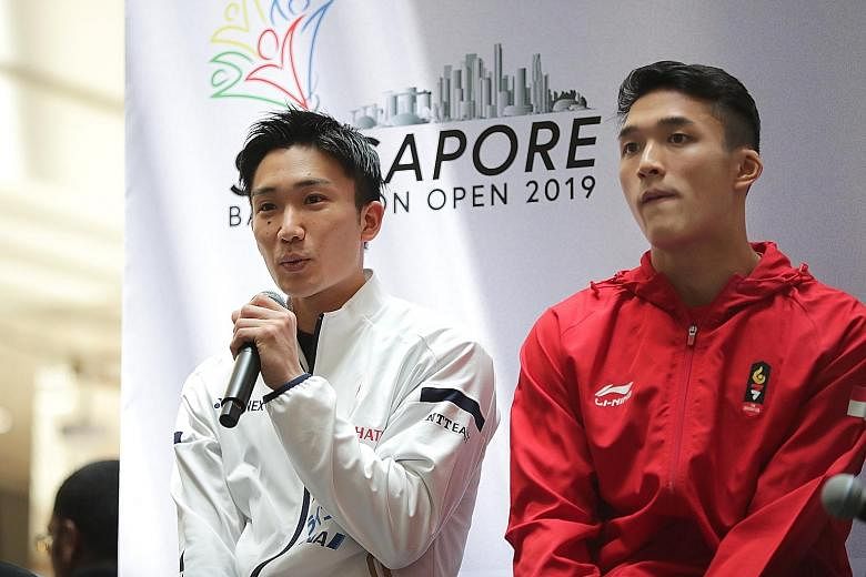 Japan's world champion Kento Momota speaking at a public press conference alongside Jonatan Christie at Wisma Atria yesterday. Both players begin their Singapore Open campaigns today.