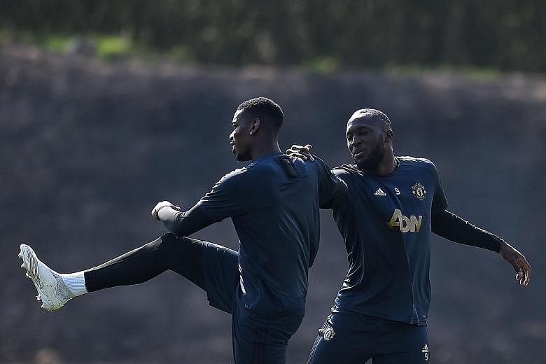 Paul Pogba (left) and Romelu Lukaku, stretching ahead of a training session at Carrington, may be key to Manchester United puncturing the hopes of Barcelona in their Champions League quarter-final.