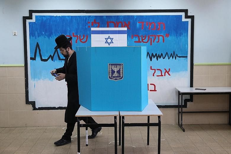 An ultra-orthodox Jewish man casting his vote at a polling station yesterday in Jerusalem, Israel. Nearly 6.3 million Israelis are eligible to vote in the election, which sees Prime Minister Benjamin Netanyahu facing closest rival Benny Gantz, a form