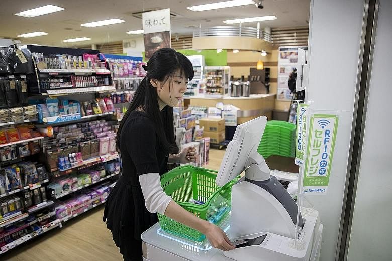 A customer paying for items at an unmanned cash register at a FamilyMart store in Tokyo. FamilyMart, which has more than 16,000 stores in Japan, says it will experiment with reduced-hour operations. It is offering 270 stores the option to join the pr