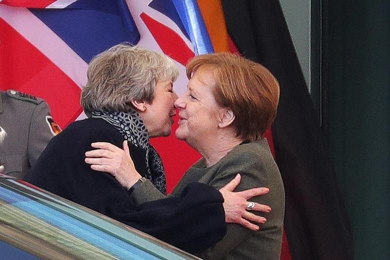 British Prime Minister Theresa May (left) embracing German Chancellor Angela Merkel in Berlin on Tuesday. Mrs May also visited Paris as part of her efforts to win a short delay to Britain's departure from the European Union ahead of an emergency Brex