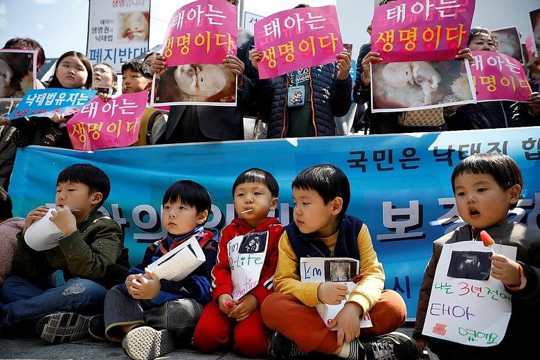 Children attending a rally supporting the abortion ban in front of South Korea's Constitutional Court yesterday. The sign reads "Foetus is life".