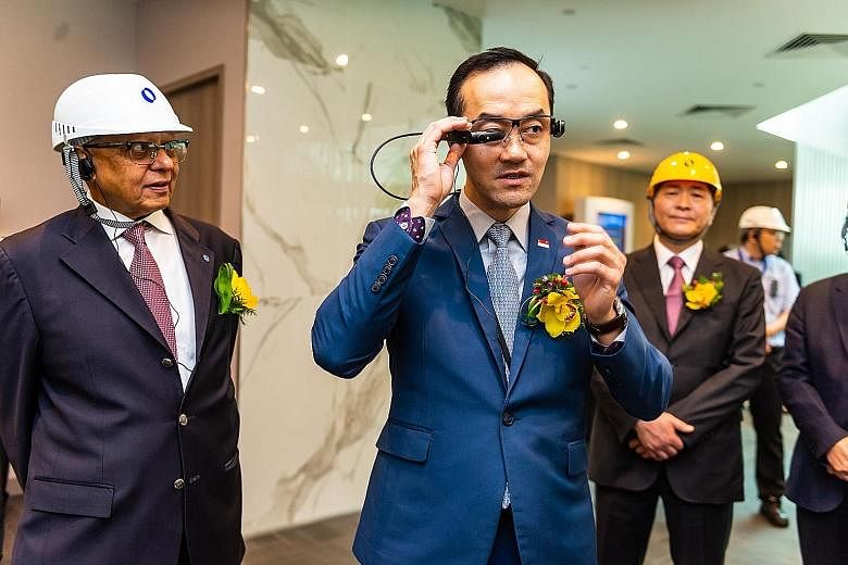 Senior Minister of State for Trade and Industry Koh Poh Koon trying out Makino Asia's Smart Glasses, which provide real-time information to engineers on the ground who are trying to fix technical faults in machines. On his left is Mr K. S. Sankaran, 