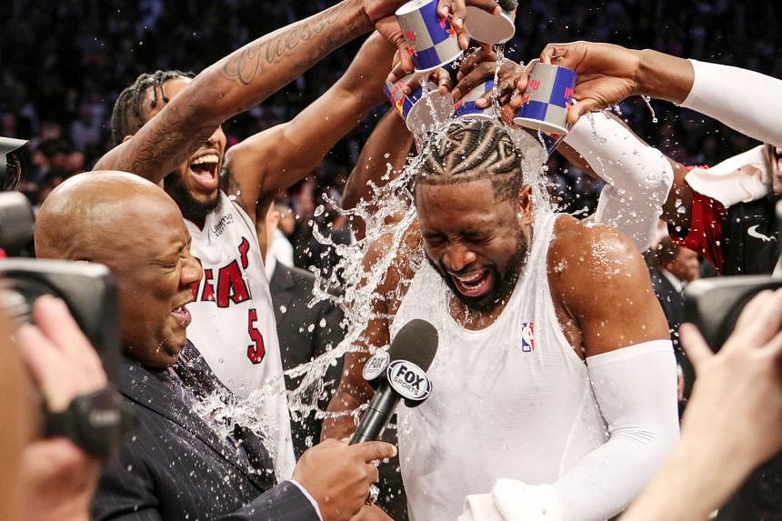 Above: LA Clippers' Montrezl Harrell dunking in the 143-137 home win over the Utah Jazz on Wednesday. Left: The retiring Miami Heat veteran Dwyane Wade being doused with water after his last game at the Brooklyn Nets.