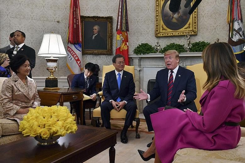 US President Donald Trump and First Lady Melania Trump (her back facing camera) meeting South Korean President Moon Jae-in and his wife, Ms Kim Jung-sook, in the Oval Office at the White House on Thursday. PHOTO: AGENCE FRANCE-PRESSE