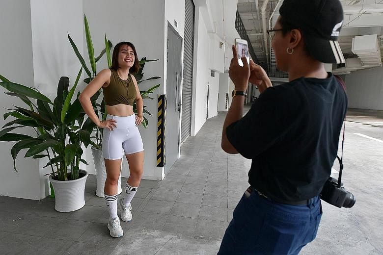 Sharpe's part-time assistant Muhammad Afifi Zaidin recording a video post for her Instagram account. Trying on a spray and make-up (left and above) in an unboxing session. Saffron Sharpe posing for photos at a fashion and lifestyle photography studio