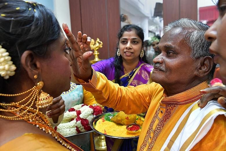 Above: Mr Velappan Vellayan applying red powder onto Madam Savithiri Kaliappan's forehead during the traditional Hindu wedding ceremony at Sree Narayana Mission Nursing Home on Friday. Right: Volunteers from the Cycling Without Age initiative prepari