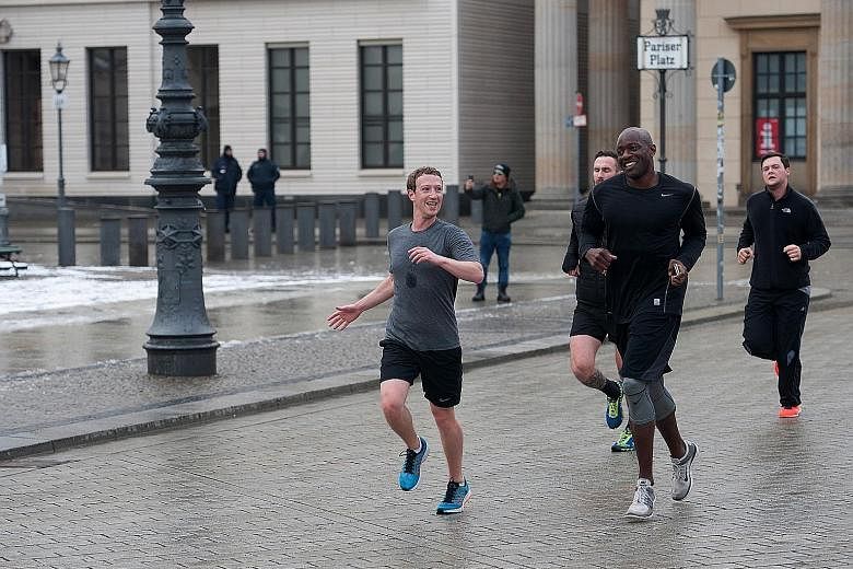 Facebook founder and chief executive Mark Zuckerberg (left) running across Pariser Platz with bodyguards in Berlin, Germany, in February 2016. The company more than doubled the money it spent on his security last year, of which nearly US$20 million w