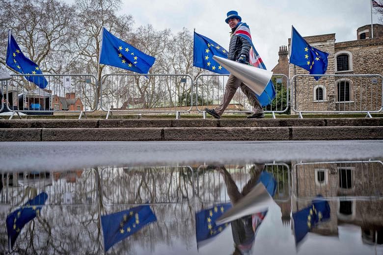 Above: An anti-Brexit protester outside the Houses of Parliament in London on March 4. Left: An anti-Brexit protester taking part in a demonstration in Brussels, Belgium, last Wednesday.