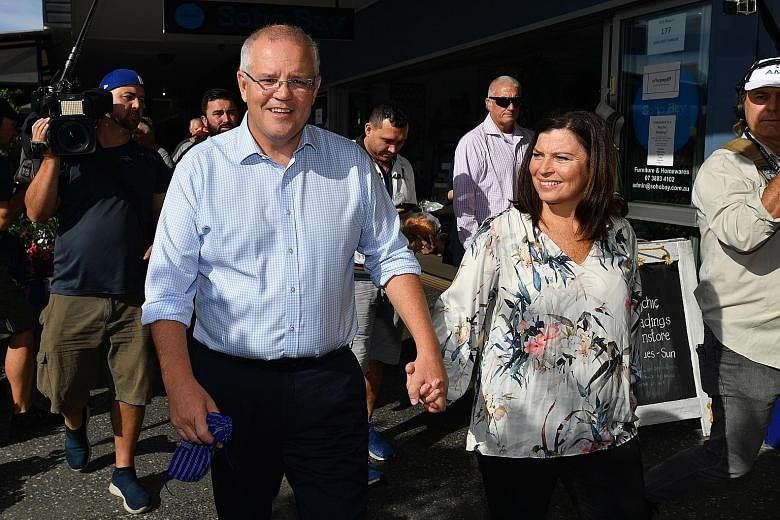 Australian Prime Minister Scott Morrison and his wife, Jenny, on a walk at the Redcliffe Jetty Markets in Brisbane yesterday. In announcing the May 18 election last Thursday, he listed various reasons why he believed Australians should vote for him, 