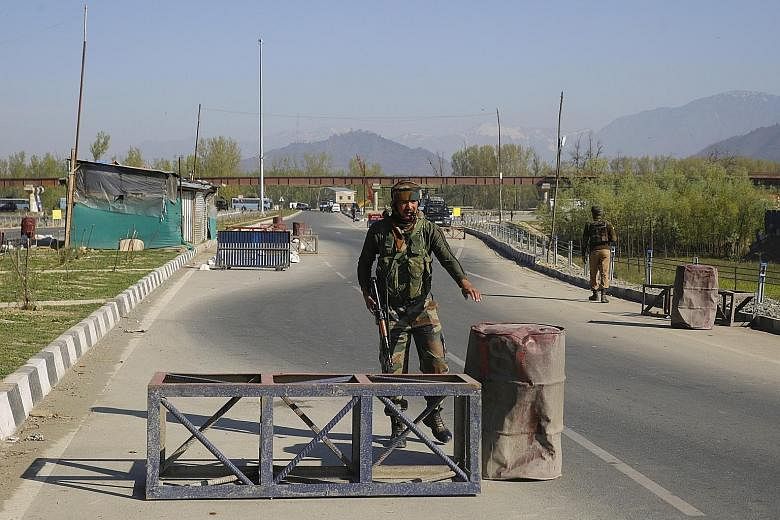 A soldier guarding Kashmir's Srinagar-Jammu highway on April 7. The government has banned civilian movement on the highway two days a week for the safe passage of Indian security convoys.