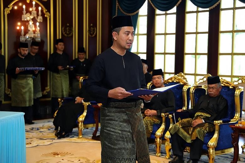 Dr Sahruddin Jamal being sworn in as Johor's 17th Menteri Besar yesterday at the main state palace, Istana Bukit Serene. The 43-year-old replaces Datuk Osman Sapian.