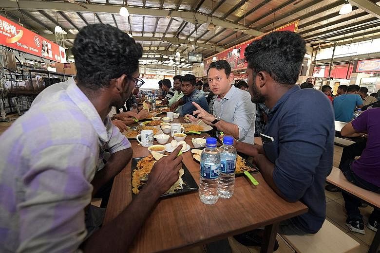 Minister of State for Manpower Zaqy Mohamad sharing a meal yesterday with foreign workers attending the Settling-In Programme at the SCAL Recreation Centre in Soon Lee Road. The one-day orientation course is currently compulsory for all new non-Malay