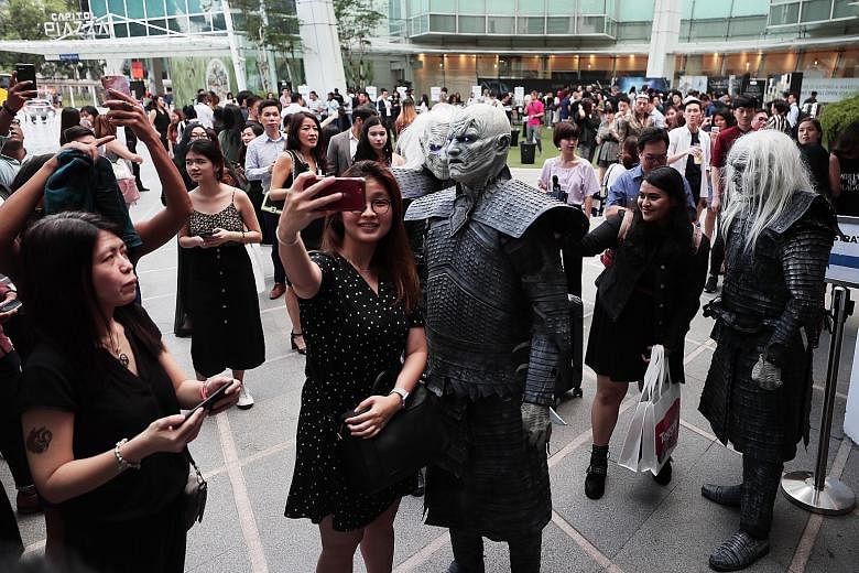 Above: The queue outside Capitol Theatre yesterday evening for the premiere screening of the first episode of the Game of Thrones' final season. Left: A fan taking a wefie with the Night King (centre), while another snapped a wefie with a White Walke