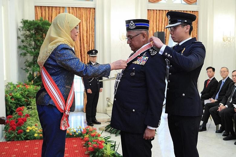 President Halimah Yacob conferring the award on Tan Sri Mohamad Fuzi Harun for his role in strengthening ties between the Malaysian and Singapore police forces. PHOTO: MINISTRY OF COMMUNICATIONS AND INFORMATION