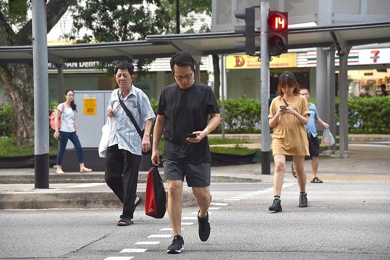 The pedestrian crossing at Block 177 Toa Payoh Central. Some have called for legislation to ban pedestrians crossing the road from using their mobile phones. The idea to fine errant pedestrians is not new. Such laws are already in place in selected A