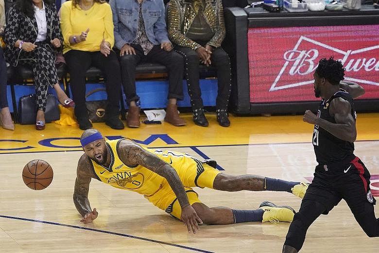 Warriors centre DeMarcus Cousins falling after injuring his left leg in the first half of the game. He was set to undergo an MRI scan yesterday. PHOTO: EPA-EFE