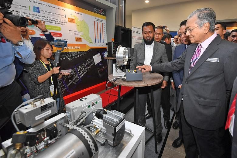 Malaysian Prime Minister Mahathir Mohamad visiting a technology exhibition in Cyberjaya yesterday. He said that a high-speed train between Singapore and Kuala Lumpur would benefit only a few states between the two cities. PHOTO: BERNAMA