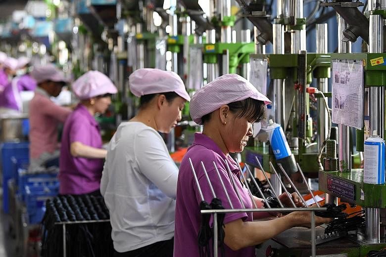 Women working on a data cable production line at a factory in Xinyu, Jiangxi province, earlier this month. Figures suggest that factory output is ticking up, shoppers are back at the tills and the world, after several tough months, is buying more Chi