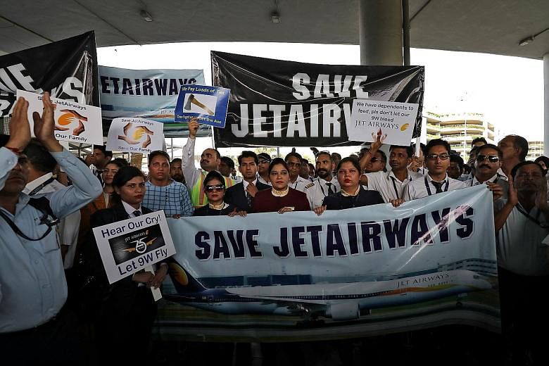 Jet Airways staff staging a protest at the Indira Gandhi International Airport, in New Delhi, last Saturday. The debt-ridden airline is seeking an immediate injection of four billion rupees (S$77.8 million) to continue its few remaining services. PHO