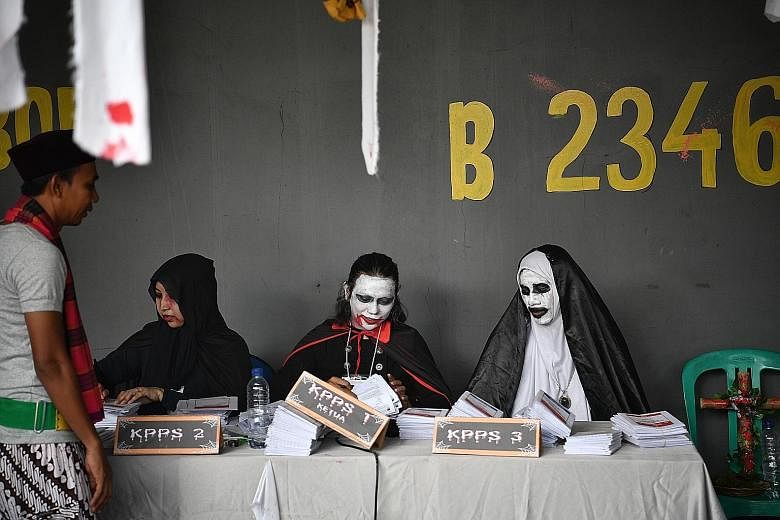 Election officials dressed in costume to match the horror theme at a polling station in Lebak Bulus, Jakarta. Officials wearing superhero costumes preparing ballot papers in Surabaya, East Java. Efforts to increase voter turnout have taken on added u