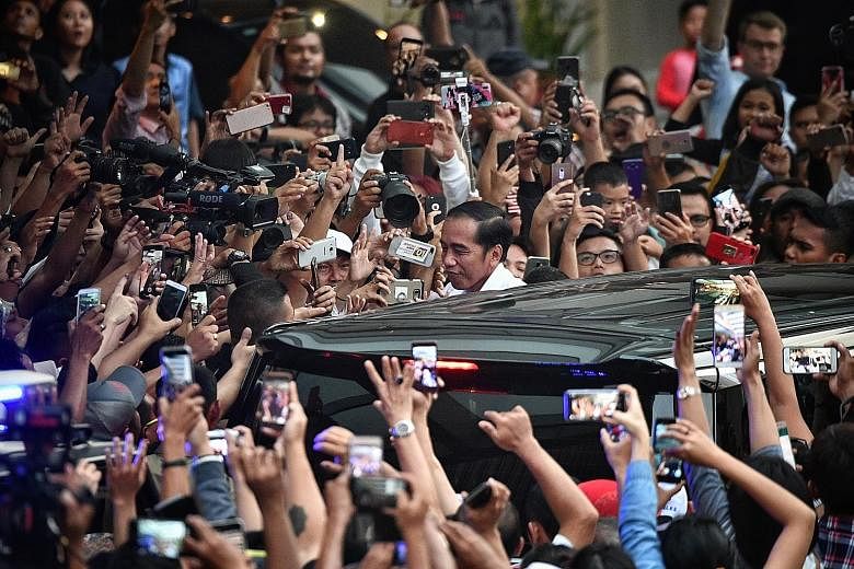 Supporters cheering as incumbent President Joko Widodo left the Djakarta Theatre in Jakarta yesterday after meeting leaders of political parties supporting his ticket. After the quick counts were released, Mr Joko called for unity, urging Indonesians
