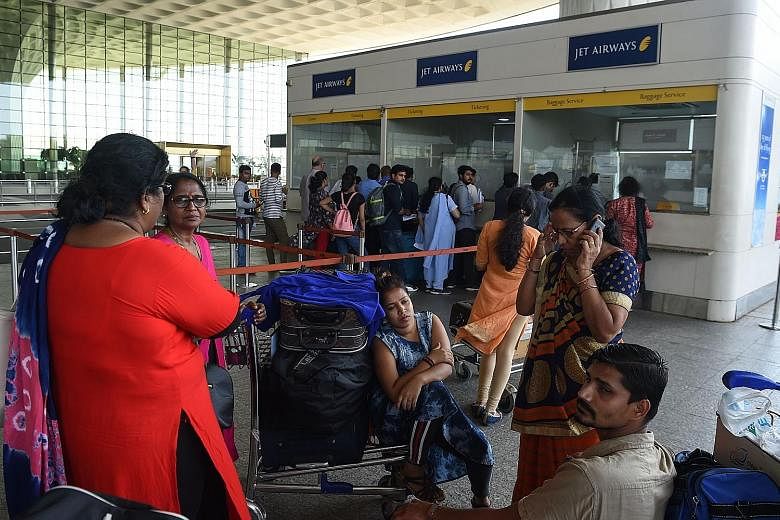 Passengers waiting by the Jet Airways ticketing counter yesterday at Chattrapati Shivaji International Airport in Mumbai. The airline's stock fell to 163.9 rupees on the Bombay Stock Exchange yesterday. It was worth more than four times that a year a