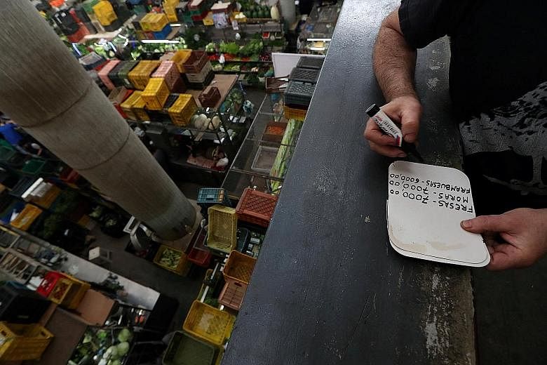 A Venezuelan man making a price list at a commercial centre in the country's capital Caracas last month. Inflation in the beleaguered South American nation is projected to hit an eyeball-popping 8 million per cent this year.