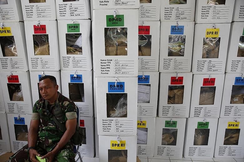 An Indonesian soldier guarding ballot boxes at a village in Depok, Indonesia yesterday, a day after the general election.