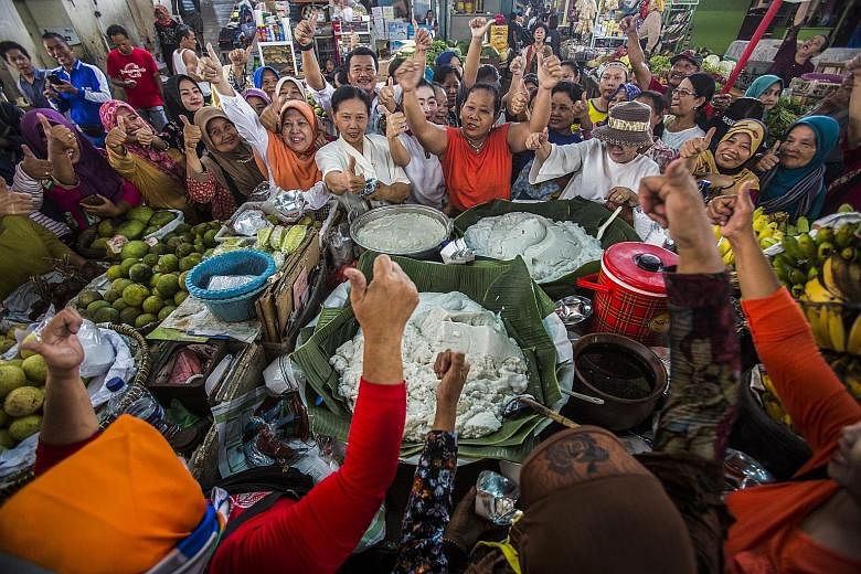 Supporters of incumbent President Joko Widodo shouting slogans yesterday as they celebrated at a local market in Solo, Central Java, after the early-count results showed he was poised to return for a second term in office. PHOTO: EPA-EFE