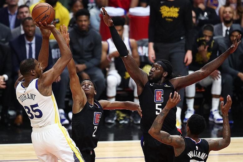 Golden State's Kevin Durant taking a shot despite the attention of the Clippers' (from left) Shai Gilgeous-Alexander, Montrezl Harrell and Lou Williams in Game 3 of their Western Conference first-round play-off series at Staples Centre on Thursday in Los 