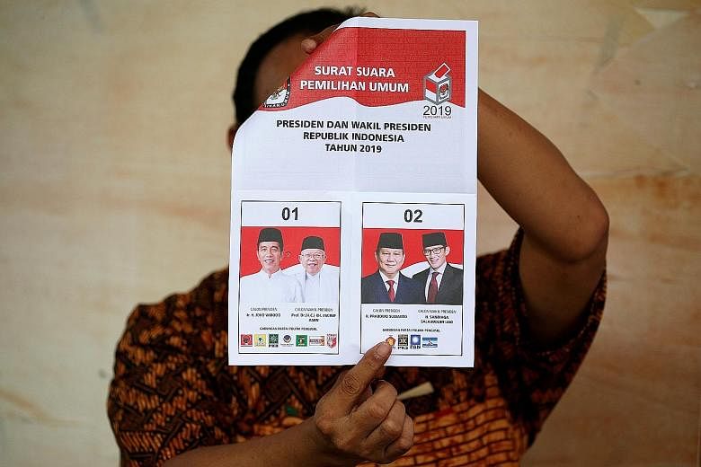A ballot paper being held up during the tallying of the results for the Indonesian elections in Jakarta on Wednesday. The General Elections Commission predicted that poll turnout would exceed its target of 77.5 per cent. PHOTO: REUTERS
