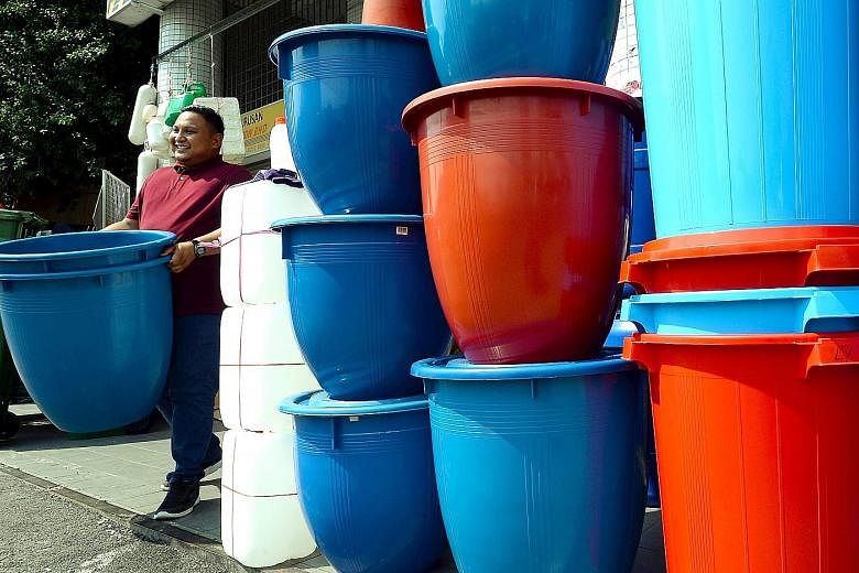 A resident with newly purchased water containers in Kuala Lumpur. The taps in Selangor state are expected to run dry for 86 hours from next Wednesday to facilitate critical repairs at a treatment plant managed by Pengurusan Air Selangor. PHOTO: THE S