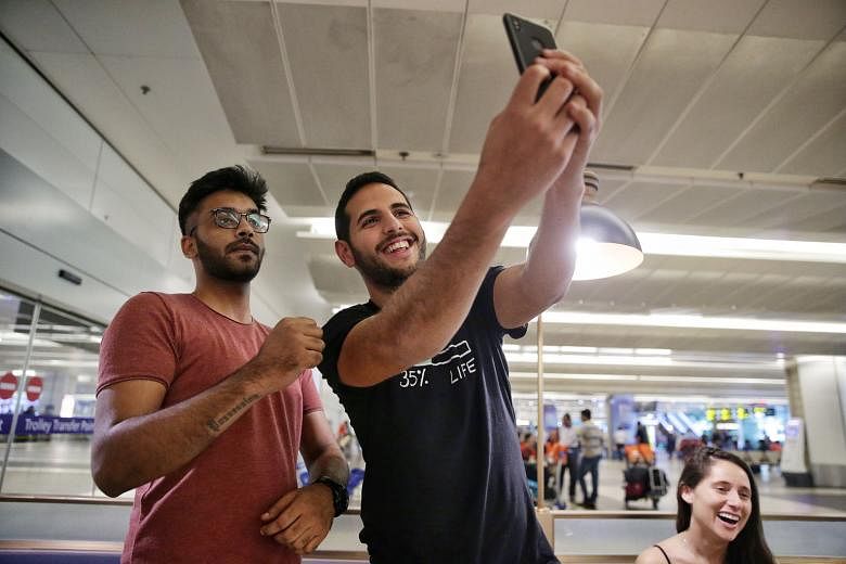 Vlogger Nuseir Yassin taking a photo with a fan at Changi Airport on Wednesday. His girlfriend, Ms Alyne Tamir, was also present. His meet-and-greet event is set to be held at the Botanic Gardens from 4pm to 6pm today.