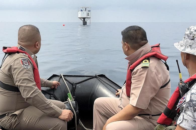 Thailand's Third Naval Area Command officers and Marine policemen observing a floating home in the Andaman Sea, some 12 nautical miles off the coast of Phuket. The couple who built the house may face the death penalty.