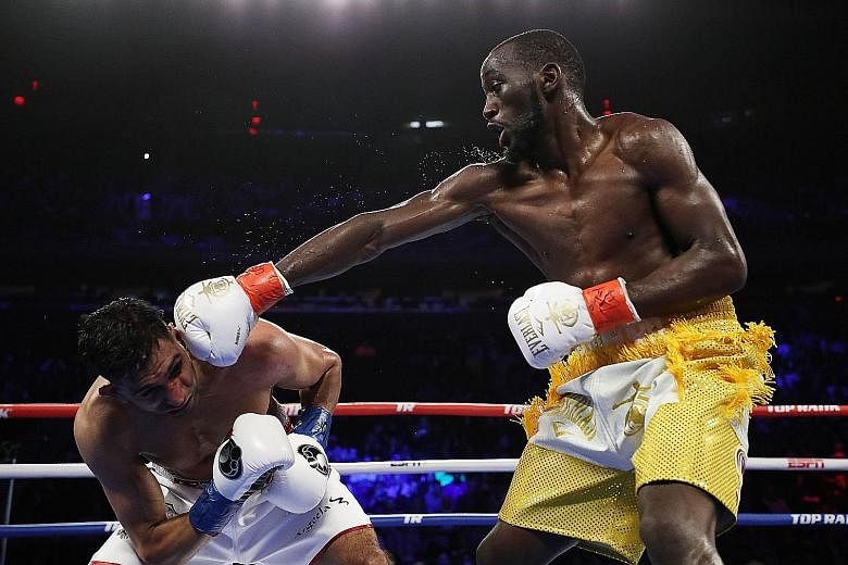 Terence Crawford sends Amir Khan grimacing with a punch at Madison Square Garden on Saturday. The undefeated American retained his WBO welterweight title by a technical knockout.