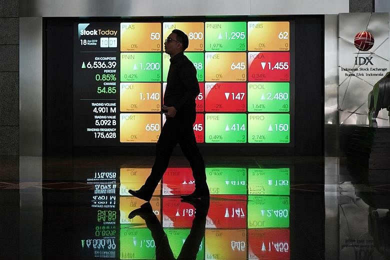 An electronic board displaying stock prices at the Indonesia Stock Exchange in Jakarta on Thursday. The Jakarta Stock Exchange ticked up past 6,500 points in trading after election day. The bourse has gained more than 5 per cent since January, while 