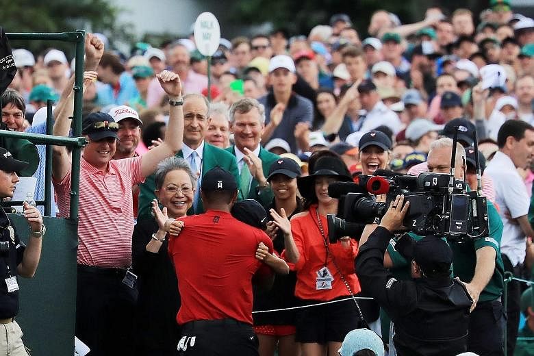 Tiger Woods hugging his son Charlie Axel while his mother Kultida looks on after he won his fifth Masters and 15th golf Major at Augusta on April 14, as daughter Sam waits to join in the celebrations.