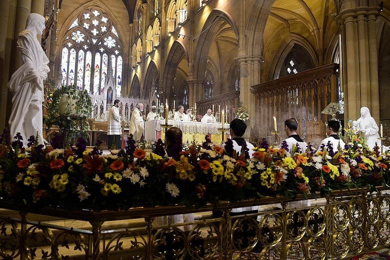 Altar boys preparing to enter the Cathedral of the Good Shepherd in Singapore in a procession at the evening Easter Sunday mass yesterday. ST PHOTO: LIM YAOHUI People at an Easter Sunday mass in tribute to the Notre-Dame cathedral at the Saint-Eustac